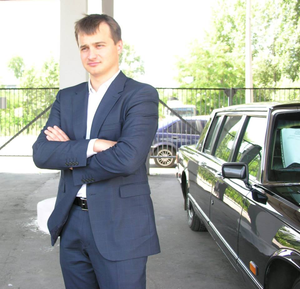 Сергій Березенко позує на тлі автомобілів із автопарку. Фото: Сергій Березенко/facebook.com