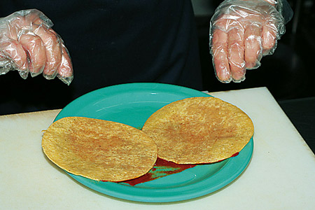 В тарелку налить столовую ложку соуса анчо и покрыть им лепешки с одной стороны