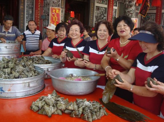 Группа тайваньских женщин делает цзунзы к Фестивалю лодок-драконов для пожилых одиноких людей. (Huang Liyi/The Epoch Times)