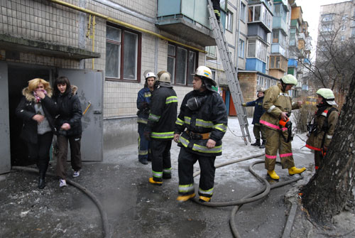 Девушки выбегают из подъезда, где загорелась квартира.  Утром 1 января в квартире на первом этаже пятиэтажки в Отрадном р-не г. Киева по адресу Василенко 23 - б разгорелся пожар. Фото: Владимир Бородин/Великая Эпоха.