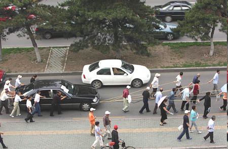 Чанчунь. Звільнені робочі тягнуть автомобіль свого начальника, щоб продати й отримати зарплату, яку не видають їм декілька років. Фото: Getty Images