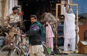 Пакистанский военный стоит на страже, в то время как жизнь возвращается в норму в Ларкане - родном городе убитого экс-премьера Пакистана Беназир Бхутто. Фото: Asif Hassan/AFP/Getty Images