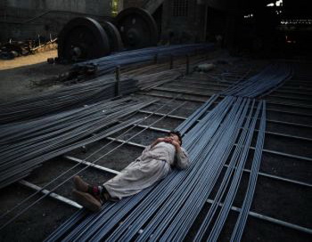 Работник металлургического комбината спит на стальных прутьях, Исламабад, Пакистан, 29 ноября 2010 года. Фото: Карл Де Соуза/AFP/Getty Images