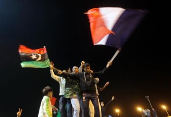 Ливийцы в осажденном городе Бенгази празднуют решение о принятии резолюции Совета Безопасности Организации Объединенных Наций, которая запрещает полеты над Ливией. (Patrick Baz/Getty Images)