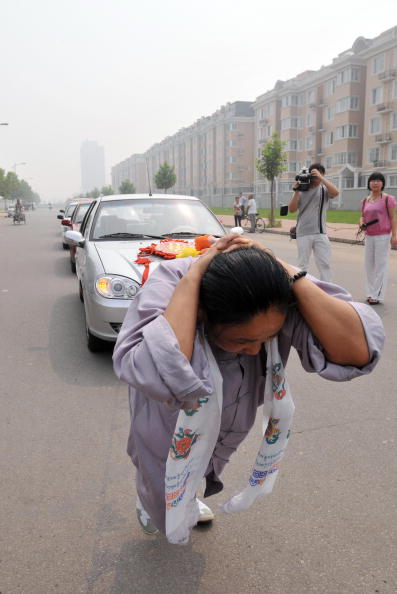 Китаянка Чжан Тінтін протягнула на своїй косі 6 автомобілів. Фото: AFP / Getty Images