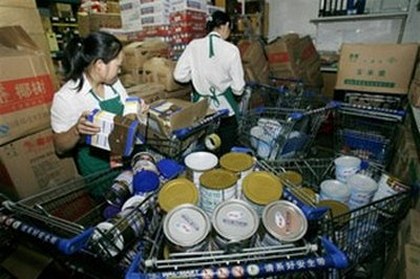 Работники супермаркета г.Ухань снимают с продажи сухое молоко фирмы «Саньлу». Фото: AFP