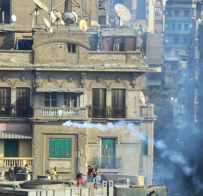 Шашка сльозогінного газу, випущена єгипетським омонівцем, пролетіла над головами протестувальників, які стоять на даху бібліотеки Американського університету, недалеко від площі Тахрір у Каїрі. 23 листопада 2011 Фото: Khaled Desouki/Getty Images
