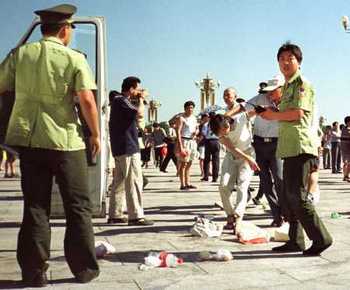 Китайские полицейские на улице арестовывают последовательницу Фалуньгун. Фото с epochtimes.com