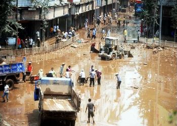 Жители посёлка Гуанан провинции Сычуань очищают улицы от грязи после наводнения. Фото с epochtimes.com