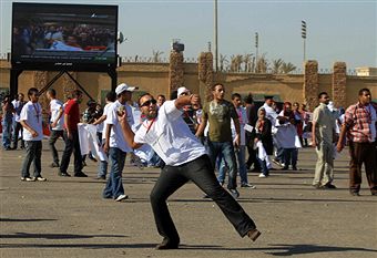 Египтяне, лояльные к бывшему президенту Египта Хосни Мубараку дерутся с противниками его режима за стенами полицейской академии, где проходит судебное разбирательство над должностными лицами свергнутого правительства. 3 августа 2011 года. Фото Khaled Deso