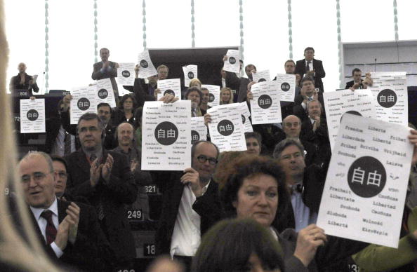 Депутаты Европарламента держат листы с надписью в центре на китайском «свобода». Фото: AFP