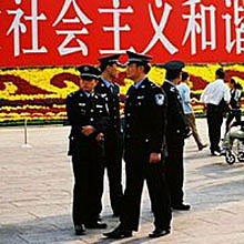 Фото: Міліціонери патрулюють площу Тяньанмень в державне свято 1 жовтня 2006 року. Гасло позаду них свідчить: 'Соціалістичне, гармонійне суспільство'