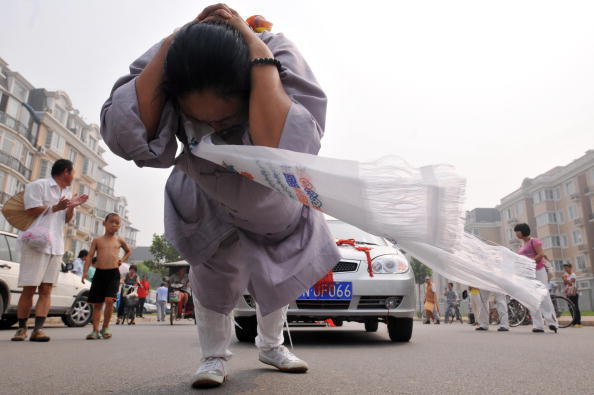 Китаянка Чжан Тінтін протягнула на своїй косі 6 автомобілів. Фото: AFP / Getty Images