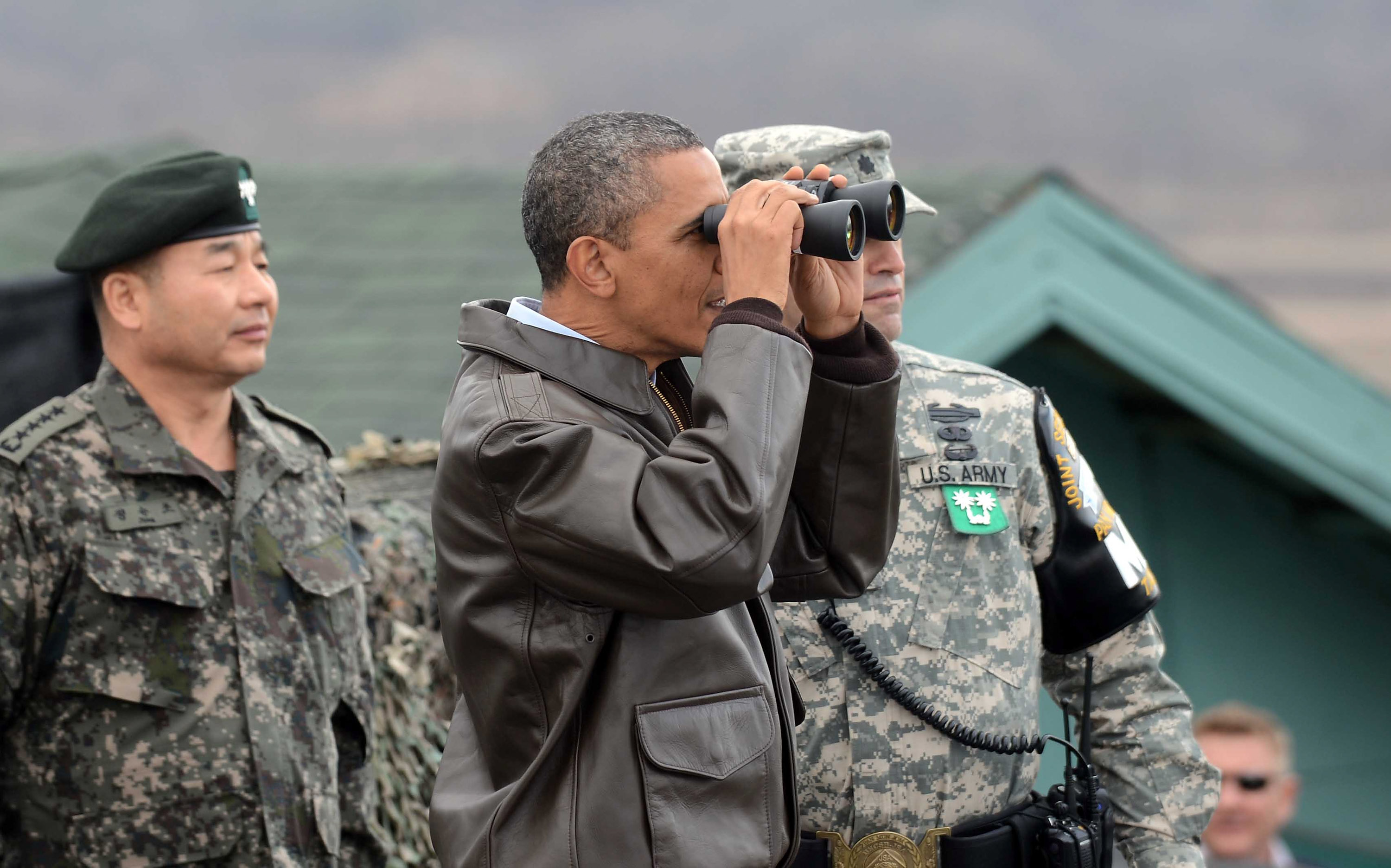 Барак Обама на территории Южной Кореи смотрит через бинокль на КНДР. Фото: Yonhap News via /Getty Images