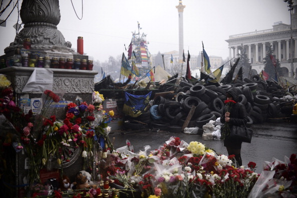 Жінка сумує поблизу знака данини пошани жертвам лютневих зіткнень між антиурядовими демонстрантами і беркутом на Майдані в Києві, 3 березня 2014 року.Фото: DIMITAR DILKOFF/AFP/Getty Images