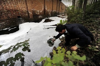 Китайский эколог берёт пробы воды в водоёме рядом с заводом в провинции Хэнань. Фото: Getty images