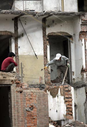 Китайські робітники руйнують старі житлові приміщення. Фото: GOH CHAI HIN/AFP/Getty Images 