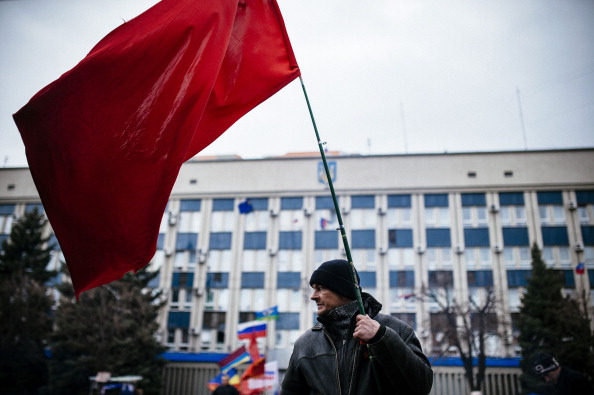 Проросійський активіст тримає прапор Радянського Союзу біля управління Служби безпеки України у Луганську, 13 квітня 2014 року. Фото: DIMITAR DILKOFF/AFP/Getty Images