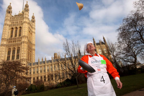 Англійські парламентарі підкидають млинці під час щорічних Млинцевих перегонів, вівторок Масляної, 9 лютого 2010 р., Лондон. Фото: Oli Scarff / Getty Images