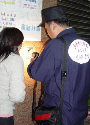 Тайваньский полицейский исследует поврежденный блок контроля. Фото: The Epoch Times