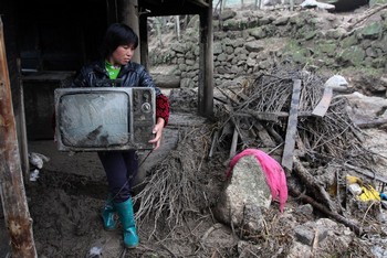 Жительница деревни провинции Хубэй спасает от наводнения своё имущество. 15 мая 2010 год. Фото: AFP