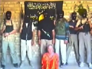 Розмите фото групи терористів, розміщене в Інтернеті в 2004 році. На ньому видно: британський заручник Кен Біглі до своєї страти. Фото: Getty Images