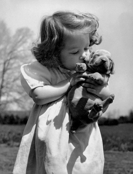 Христина Голдсміт цілує цуценя на складі свого батька. Фото: журнал LIFE 12 червня, 1950 р.