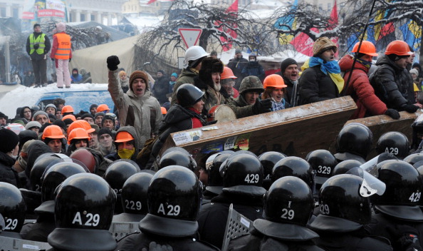 «Анти-Янукович» закликає захищати свої барикади перед силами поліції на Майдані Незалежності в Києві 11 грудня 2013 року. Фото: VIKTOR DRACHEV/AFP/Getty Images