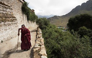 Літній чернець Тибету йде по пагорбу до монастиря Дрепунг в автономній області Тибету Китаю. Фото: Paula Bronstein/Getty Images)