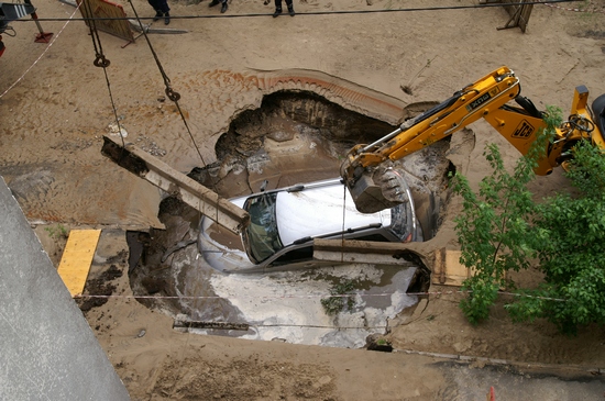 Іномарка провалилась під землю у Києві. Фото: The Epoch Times