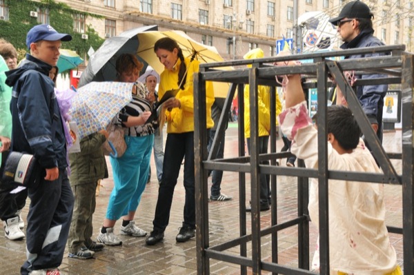 Учасниця акції послідовників Фалуньгун збирає підписи за звільнення однодумниці, яку катують у китайській в'язниці. Фото: Володимир Бородін/The Epoch Times Україна 
