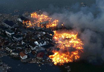 Будинки, що горять після удару цунамі в місті Наторі у префектурі Міяги, після сильного землетрусу в Японії 11 березня 2011 року. Фото: AFP PHOTO / Yomiuri Shimbun