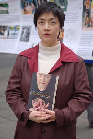 Дженіфер Цзен тримає в руках автобіографічну книгу «Історія свідка», в якій описані пережиті нею події в Китаї, - вона зазнала репресій за те, що займається Фалуньгун. Фото: The Epoch Times