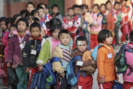 Діти мігруючих робітників очікують шкільного автобуса в провінції Гуандун, Китай. Діти робітників з низьким доходом перебувають в більшій небезпеці, будучи одягненими в одяг, який насичений токсичними і канцерогенними речовинами. Фото: Getty Images