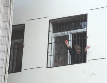 Пен Юнкан через загратоване вікно психіатричної лікарні махає своїм друзям рукою і просить, щоб вони забрали її звідти. Фото: Civil Rights & Livelihood Watch