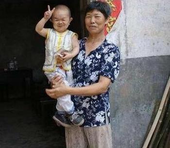 Претендент на рекорд Книги Гиннеса, 40-летний Хуан Кайцюань на руках у своей мамы. Фото с epochtimes.com