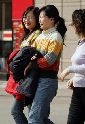 Через незвичайно теплу погоду в Пекіні в лютому люди знімають теплий зимовий одяг. Фото: GOH CHAI HIN/AFP/Getty Images