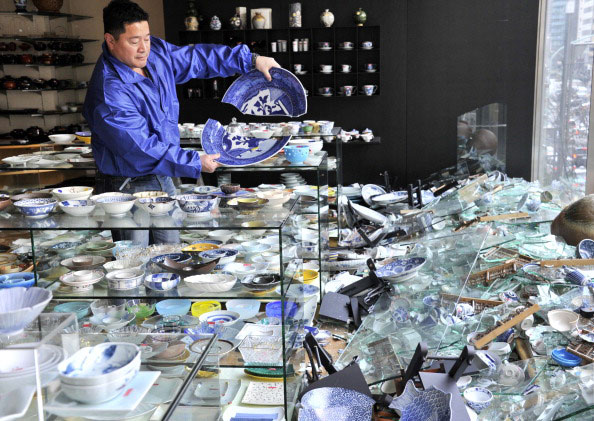 Власник магазину кераміки в Токіо перевіряє пошкодження виробів після сильного землетрусу в Японії 11 березня 2011 року. Фото: AFP PHOTO / Yoshikazu TSUNO