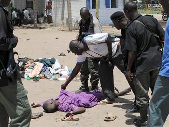 Нігерійський поліцейський дивиться на тіло нігерійського таліба, який був вбит у перестрілці з солдатами, дислокованих 28 липня, щоб придушити ісламістську секту в північному місті Майдугурі, 29 липня 2009 р. Члени радикального ісламського угруповання «Бо