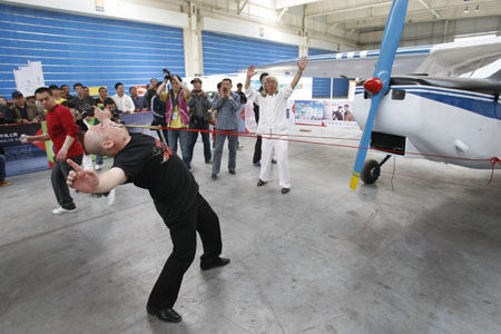 Дон Чжаншень тягне літак, прив'язаний до його повік. Фото з epochtimes.com 