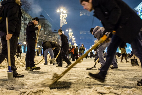 Протестувальники розчищають сніг з вулиць поблизу Майдана Незалежності 11 грудня 2013 року в Києві. Фото: Brendan Hoffman/Getty Images