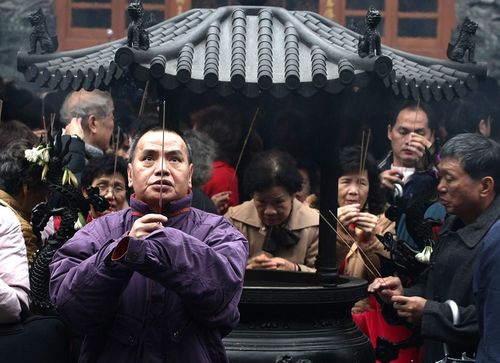У дні святкування Нового року за місячним календарем, багато китайців йдуть в храми або інші священні місця, де вони розпалюють пахощі і моляться про щастя і благополуччя. Фото: China Photos/Getty Images