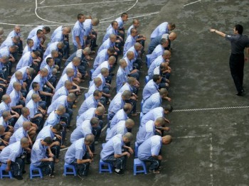 Поліцейські роз’яснюють в’язням правила хорошої поведінки. 30 травня 2005 року, м. Чунцін, КНР. Фото: China Photos/Getty Images