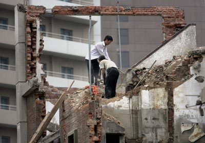 Китайські робітники руйнують старі житлові приміщення. Фото: GOH CHAI HIN/AFP/Getty Images