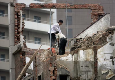 Китайські робітники руйнують старі житлові приміщення. Фото: GOH CHAI HIN/AFP/Getty Images 