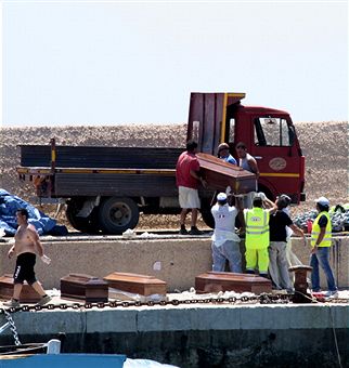 Добровольці грузять на машину труни з мертвими мігрантами, виявлені італійською береговою охороною на баржі на півдні від Сахари 1 серпня 2011. Фото: Alessia Capasso / Getty Images