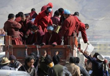 Тибетські ченці роздають благодійну допомогу жителям постраждалих від землетрусу районів провінції Цінхай. Фото: Getty Images