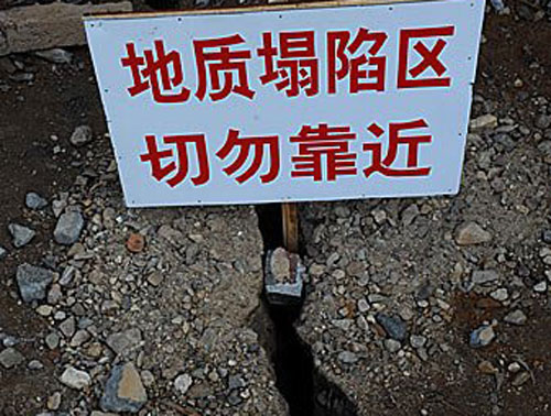 Напис на табличці: Район де провалюється ґрунт, не підходити близько. Селище Гокуан провінції Хунань. Фото з epochtimes.com 