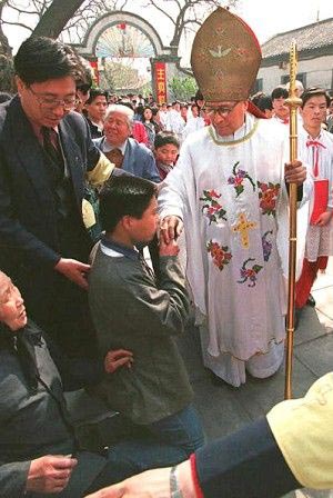 Китайський католик , що стоячи на колнах цілує кільце Єпископа Цзун Хуайде, після пасхальної служби Патріотичної Католицької Церкви Хуаньумень в Пекіні 16 квітня 2006. Фото6: Робін Бес/afp/getty Images