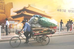 Пекин. Мужчина на трехколесном велосипеде проезжает мимо рекламного щита по защите окружающей среды. Недавно Мировой Банк издал материалы по исследованию самых грязных городов мира. 16 из 20 таких городов находятся в Китае. Фото: China Photos/Getty Images